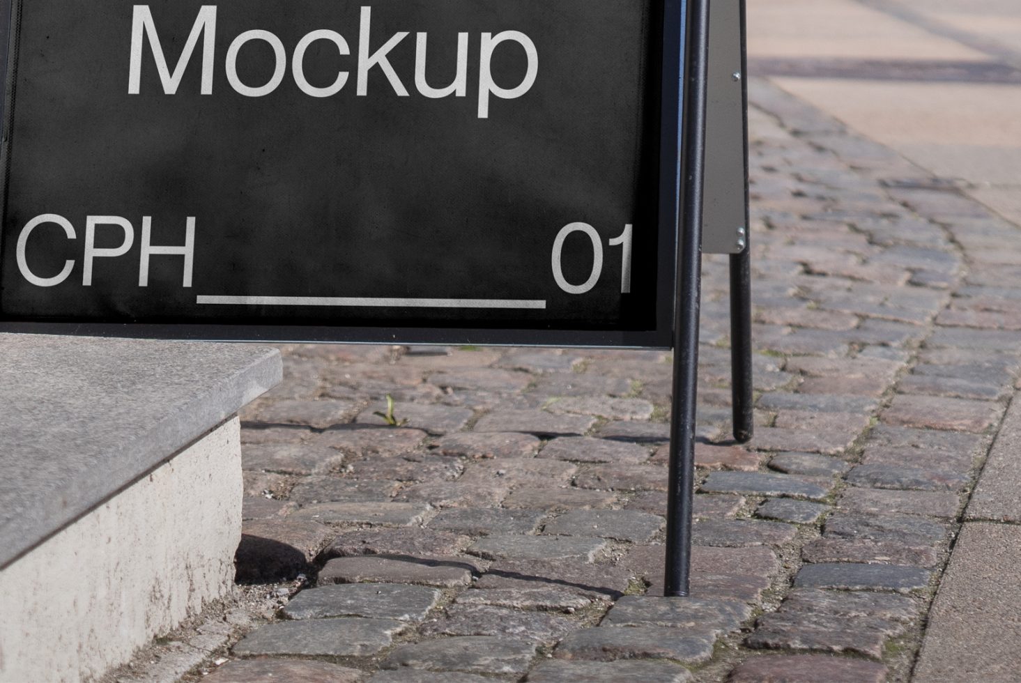 Urban outdoor sign mockup on cobblestone pavement for branding presentation, street advertising design, contemporary city signage.